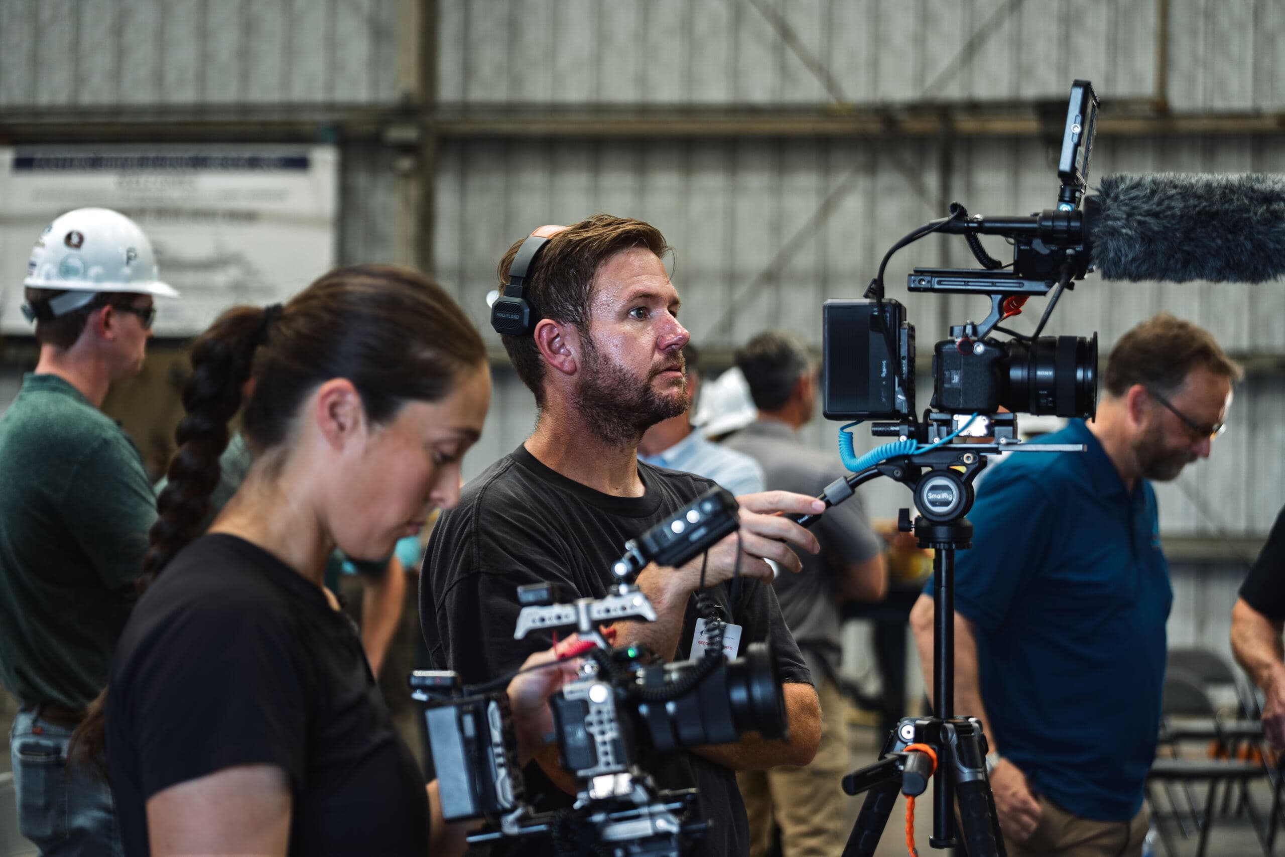 A four-person crew running camera and audio inside an industrial shop