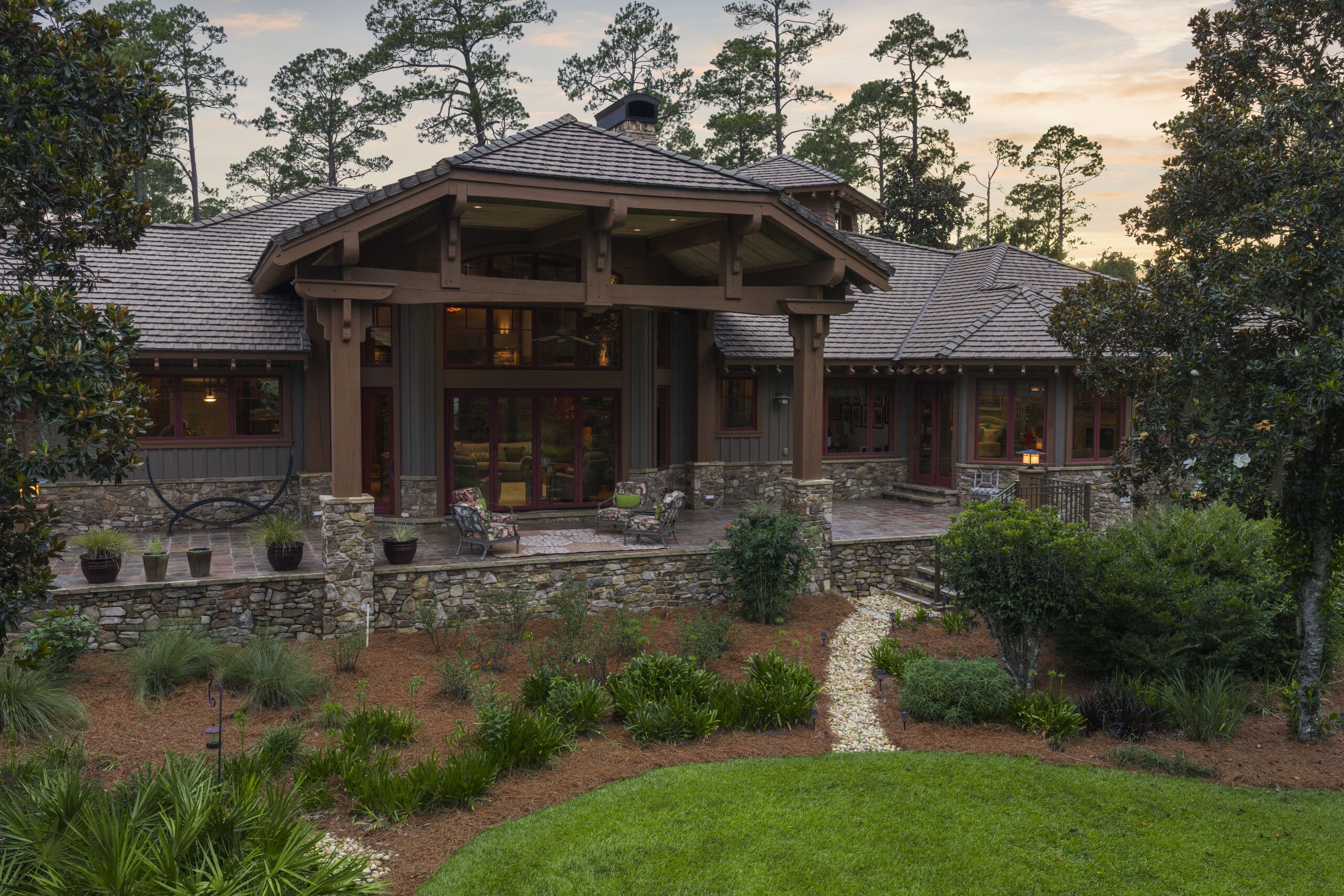 A timber-framed entrance at dusk, porch lights on