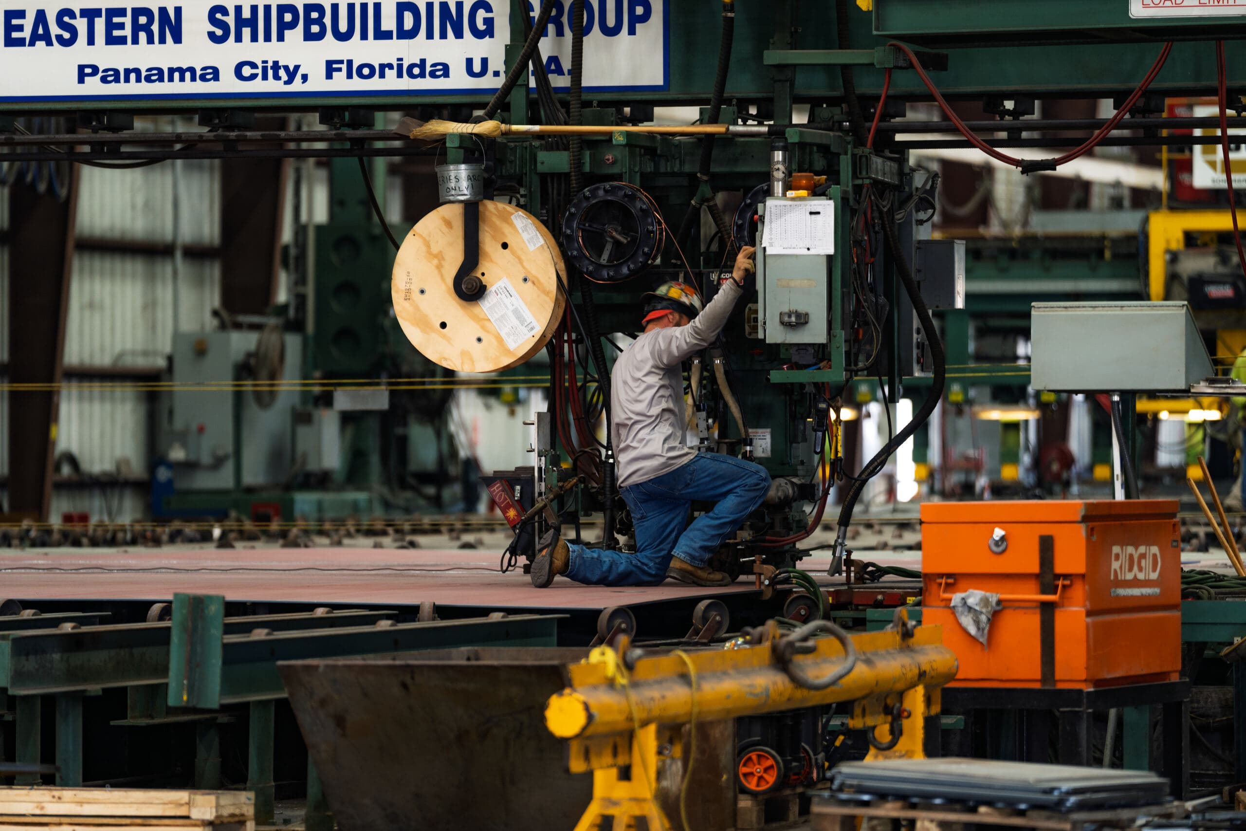 A worker running a cutting table inside the Eastern Shipbuilding fabrication shop